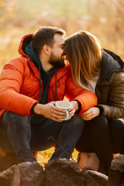 Stylish couple with cup of coffee near bonfire — Stock Photo, Image