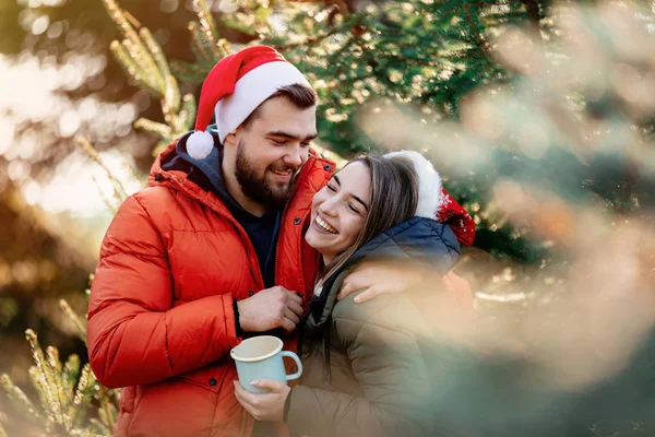 在冷杉树旁戴圣诞礼帽的浪漫夫妻. — 图库照片