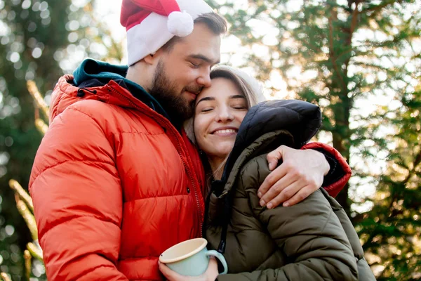 Романтическая пара в рождественских шляпах возле елки . — стоковое фото