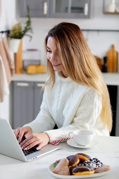 Genç bir kadın bir bilgisayarın başında çalışıyor ve çay içiyor. — Stok fotoğraf