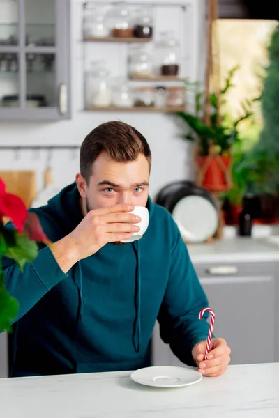 Junger Mann trinkt Cappuccino in der Küche — Stockfoto