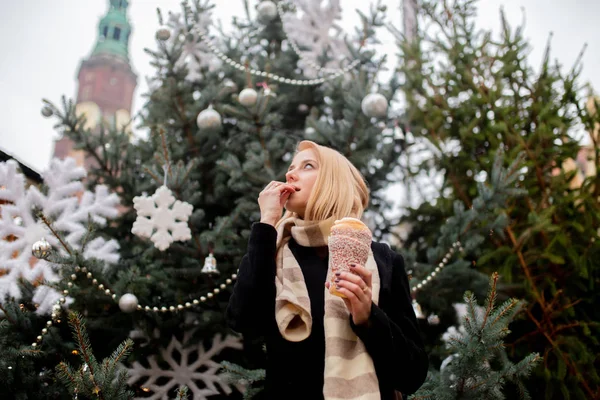 Vacker blondin med spottkaka på julmarknaden i Wrocl — Stockfoto