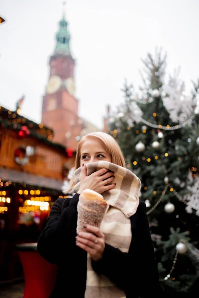 Vacker blondin med spottkaka på julmarknaden i Wrocl — Stockfoto