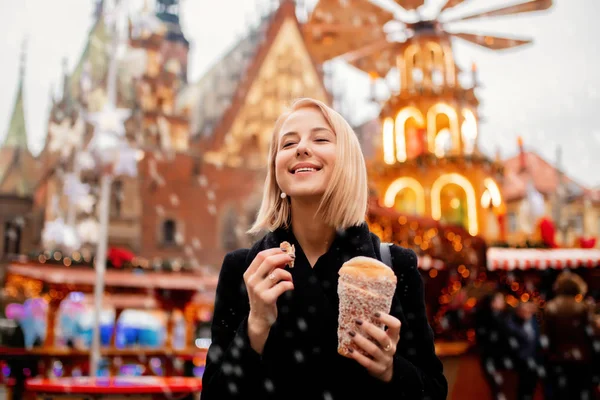 Linda loira com bolo de cuspo no mercado de Natal em Wrocl — Fotografia de Stock