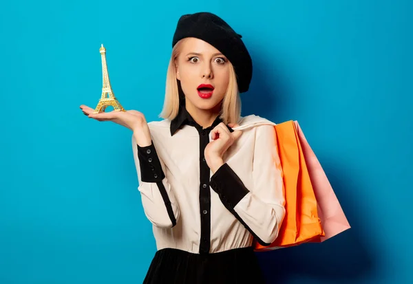 Krásná blondýna dívka s nákupními taškami a Eiffelova věž na blu — Stock fotografie