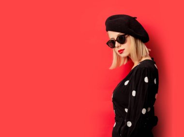 Kırmızı arka planda bereli güzel bir Fransız kadın.