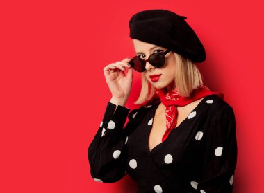 Kırmızı arka planda bereli güzel bir Fransız kadın.