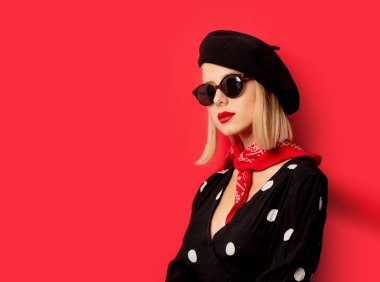 Kırmızı arka planda bereli güzel bir Fransız kadın.