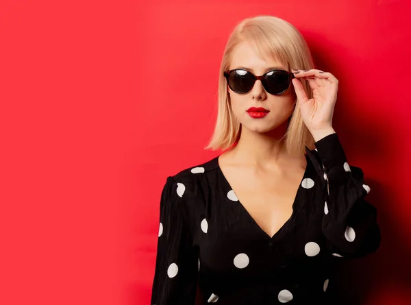 Beautiful woman in sunglasses on red background — Stock Photo, Image