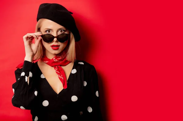 Beautiful french woman in beret on red background — Stock Photo, Image