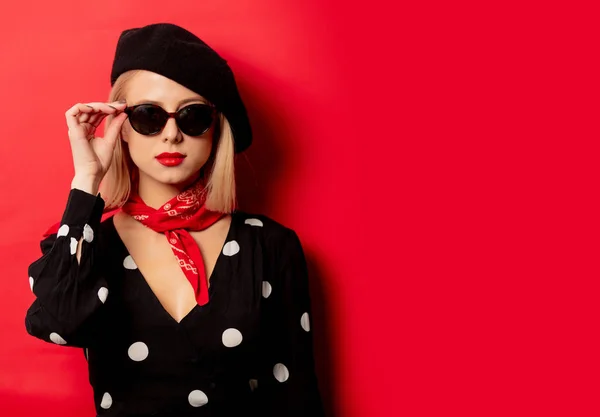 Beautiful french woman in beret on red background — Stock Photo, Image