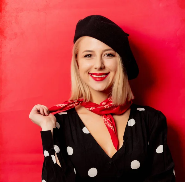 Mooie franse vrouw in baret op rode achtergrond — Stockfoto