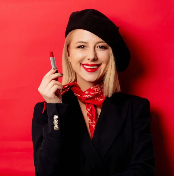 Beautiful french woman in beret with lipstick on red background — Stock Photo, Image