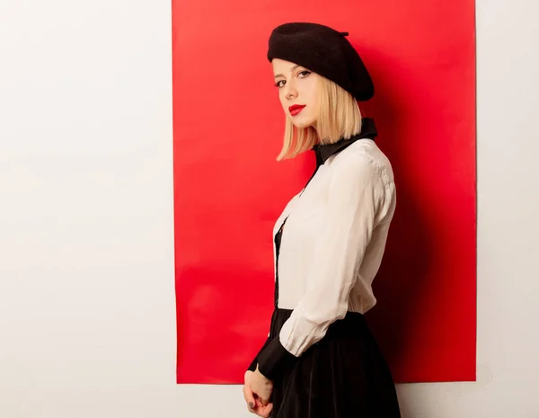 Mooie franse vrouw in baret op rode achtergrond — Stockfoto