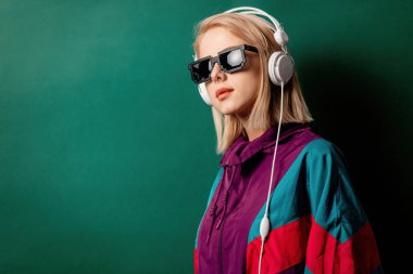 Güneş gözlüklü, kulaklıklı bir kadın. B renginde.