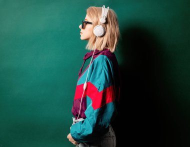 Güneş gözlüklü, kulaklıklı bir kadın. B renginde.