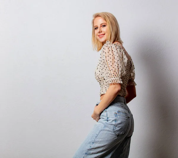 Stylowa blondynka w jeansowych dżinsach i bluzce w kropki — Zdjęcie stockowe