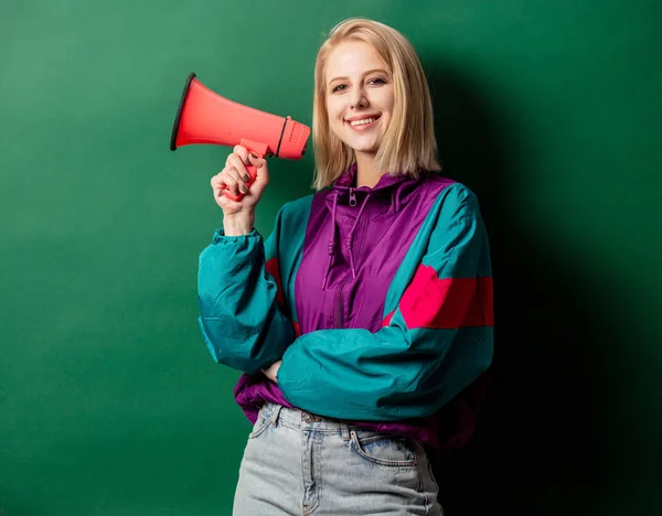 Woman in 90s style punk jacket with loudspeaker on green backgro — Stock Photo, Image