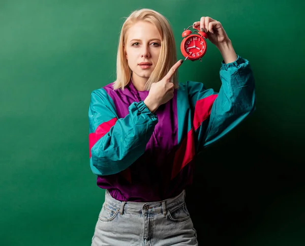 Mujer en 90 estilo chaqueta punk con despertador en backgro verde — Foto de Stock