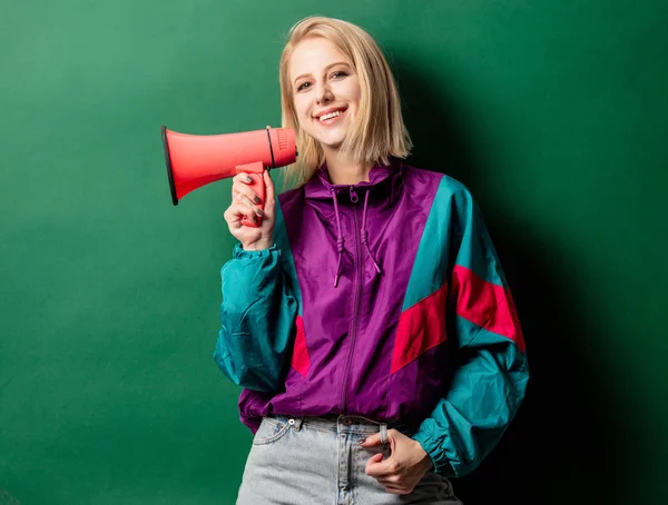 Woman in 90s style punk jacket with loudspeaker on green backgro — Stock Photo, Image