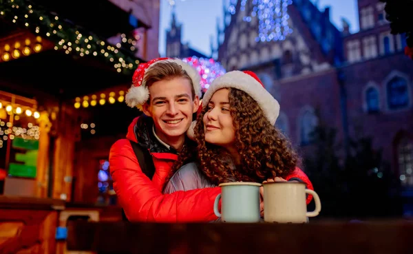 Молодая пара с напитками на Рождественской ярмарке во Вроцлаве, Польша — стоковое фото