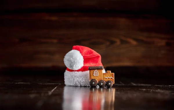圣诞老人的帽子和木制桌子上的姜饼 — 图库照片