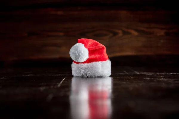 Papai Noel chapéu na mesa de madeira e fundo — Fotografia de Stock