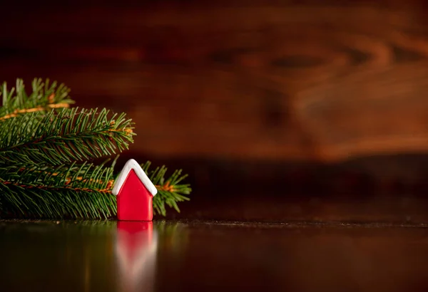 Piccolo giocattolo della casa e ramo dell'albero di Natale sul tavolo di legno — Foto Stock