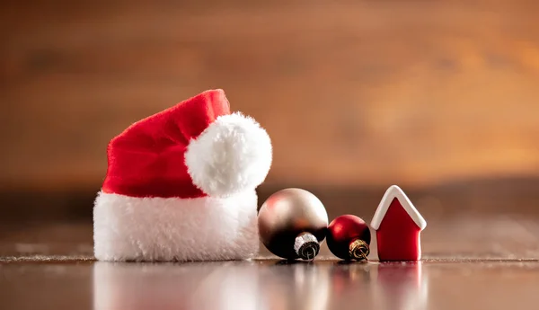 Sombrero y casita de Papá Noel sobre mesa de madera y fondo —  Fotos de Stock