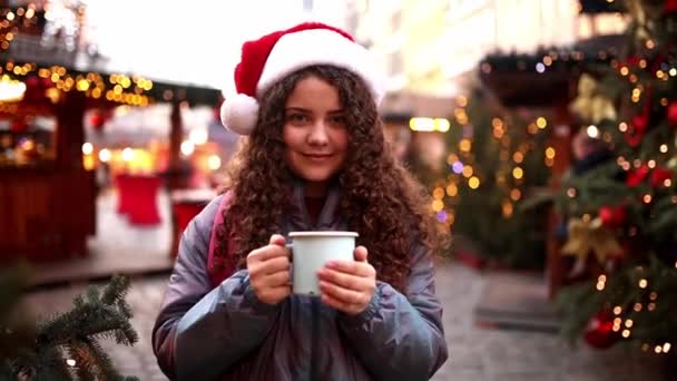 在波兰弗罗茨拉夫的圣诞市场上喝酒的年轻女孩 — 图库视频影像