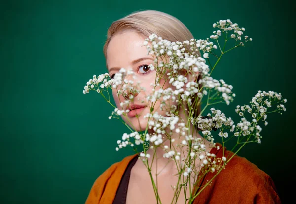 Mooie vrouw met gypsophila bloem op groene achtergrond — Stockfoto