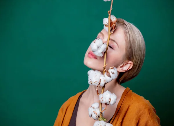 Vrouw houdt katoen tak op groene achtergrond — Stockfoto