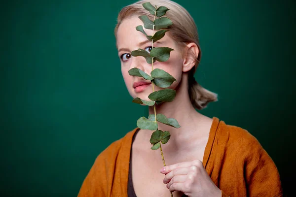 Donna tiene ramo di eucalipto su sfondo verde — Foto Stock