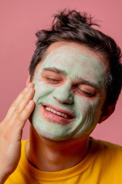 Yüzünde yosun maskesi olan güzel esmer bir adam.