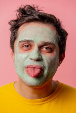 Yüzünde yosun maskesi olan güzel esmer bir adam.