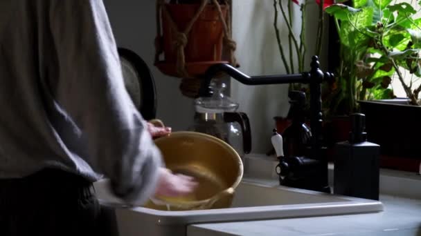 Woman washes a pan in her kitchen — Stock Video