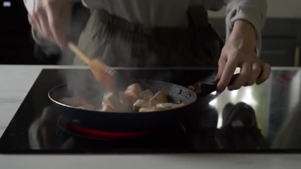 Mulher assa um frango em uma panela de ato de fritar — Vídeo de Stock