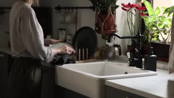 Γυναίκα σκουπίζει τα πιάτα στην κουζίνα — Αρχείο Βίντεο