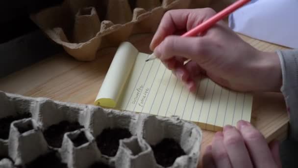 Женщина сажает семена овощей в коробки с яйцами — стоковое видео