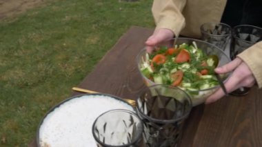 Kadın masaya salata serer.