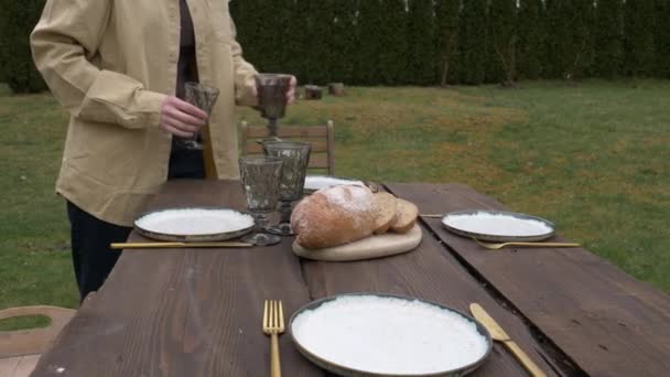 Mujer pone platos sobre la mesa — Vídeos de Stock