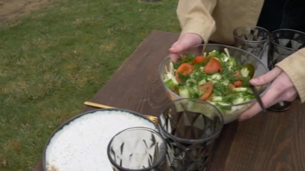 Kvinna lägger ut sallad på ett bord — Stockvideo