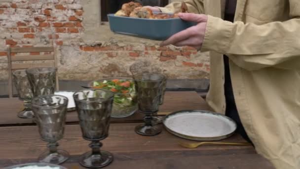 Γυναίκα απλώνει φαγητό σε ένα τραπέζι στην πίσω αυλή — Αρχείο Βίντεο