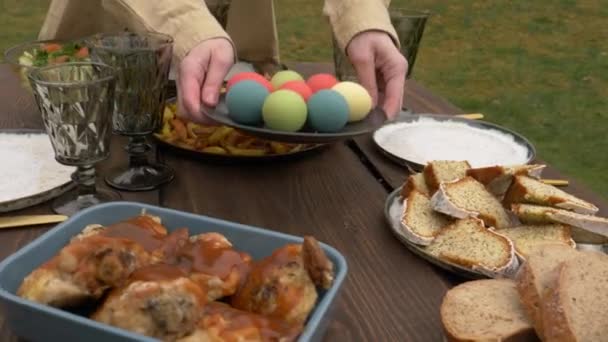 Woman lays out food on a Easter dinner — 비디오