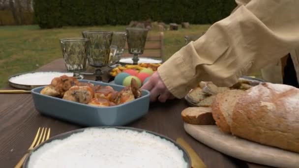 Woman lays out food on a Easter dinner — 비디오