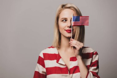 Güzel kız gri arka planda Amerika Birleşik Devletleri bayrağını taşıyor
