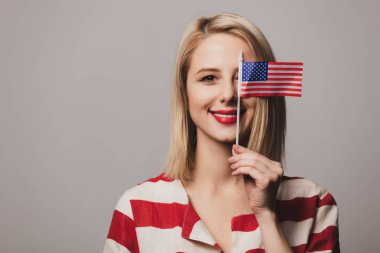 Güzel kız gri arka planda Amerika Birleşik Devletleri bayrağını taşıyor