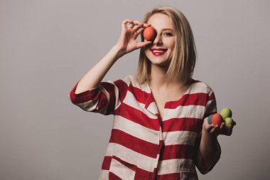 Güzel kız gri arka planda Paskalya yumurtalarını tutuyor.