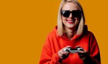 Güneş gözlüklü kız, joystick ile oynuyor.