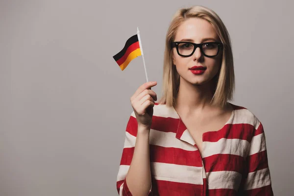 丰满的女孩在灰色背景下高举德国国旗 — 图库照片